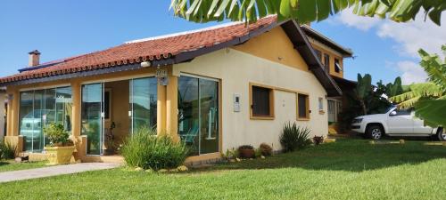 a house with a car parked in front of it at Pousada Atlântica stay home in Tramandaí