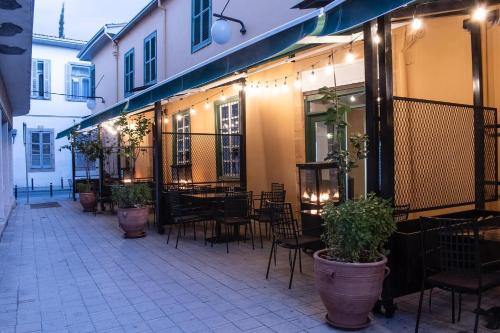 un patio al aire libre con mesas, sillas y plantas en Madama Residence en Nicosia