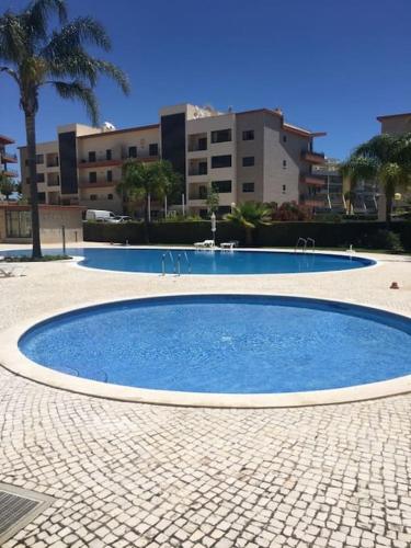 a large blue pool in a courtyard with buildings at 3 Bedroom apartment with pool in Lagos in Lagos