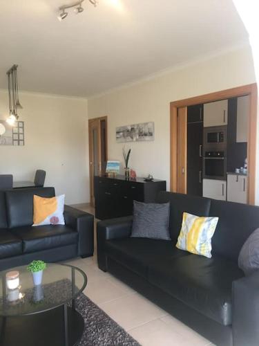a living room with two black couches and a table at 3 Bedroom apartment with pool in Lagos in Lagos