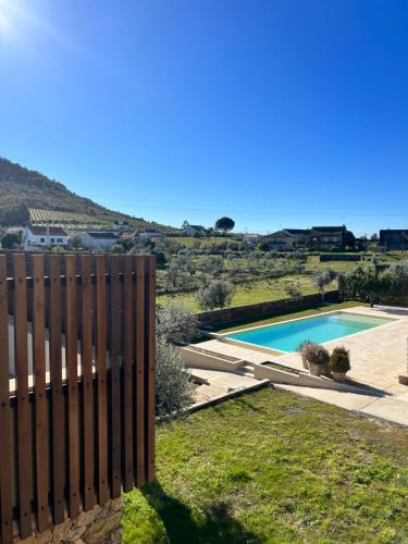 un patio trasero con piscina y valla en Raízes Turismo Rural, en Castelo Branco