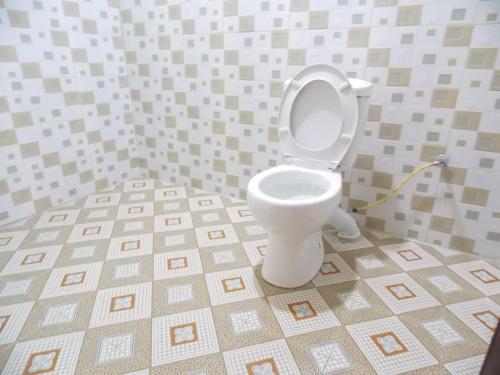 a bathroom with a toilet in a tiled room at Cloud9 Suites in Kitale