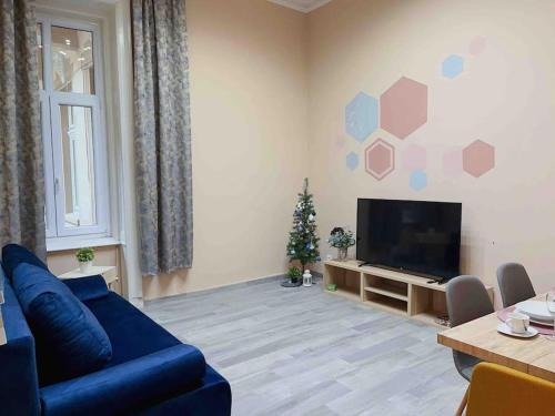 a living room with a blue couch and a christmas tree at Buda Castle Charming 2 bedrooms in Budapest