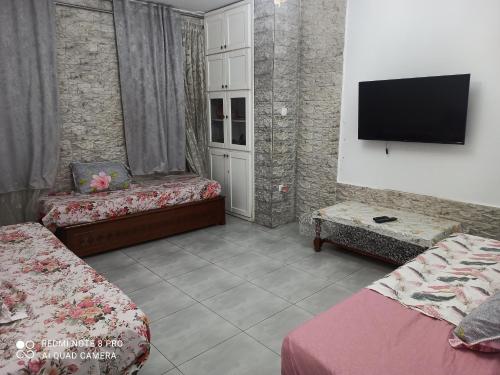 a room with two beds and a flat screen tv at عين النعجة جسر قسنطينة الجزائر Ain Naadja 