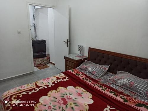 1 dormitorio con cama con colcha y almohadas rojas en عين النعجة جسر قسنطينة الجزائر Ain Naadja, 