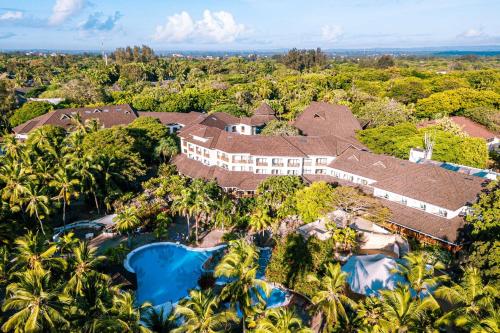 een luchtzicht op een resort met een zwembad en bomen bij Diani Reef Beach Resort & Spa in Diani Beach