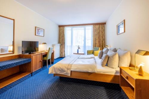 ein Hotelzimmer mit einem Bett und einem TV in der Unterkunft acora Bonn Living the City in Bonn