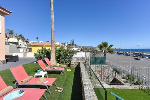 een rij tafels en stoelen op een gazon bij Chalet Santa Ana 2 by VillaGranCanaria in Playa del Inglés