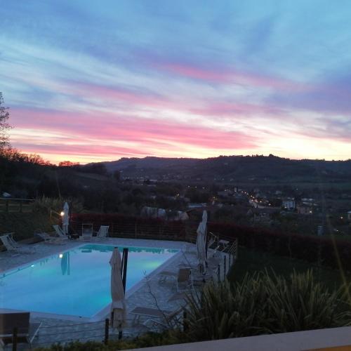 a swimming pool with a sunset in the background at B&B CasalFarano in Cupra Marittima