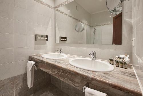 a bathroom with two sinks and a mirror at Hotel d'Allèves in Geneva