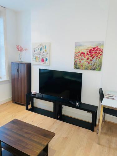 a living room with a large flat screen tv at Amazing 2 bedroom apartment in London