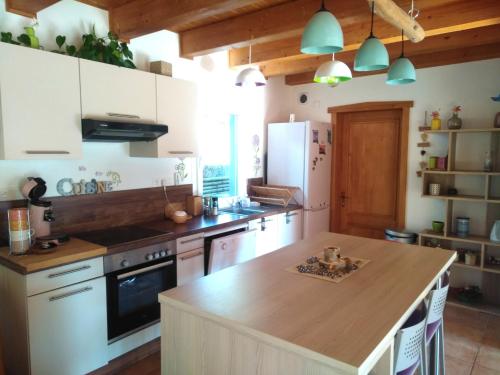 a kitchen with white cabinets and a wooden counter top at Le Cocon de l'Epicléa, Chorges, entre lac et montagnes in Chorges