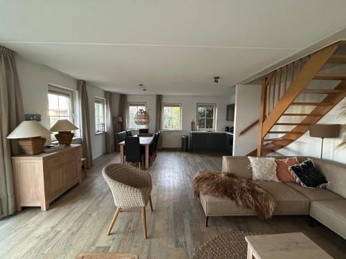 una sala de estar con un sofá y una mesa en Wadden Villa 12, en Hollum