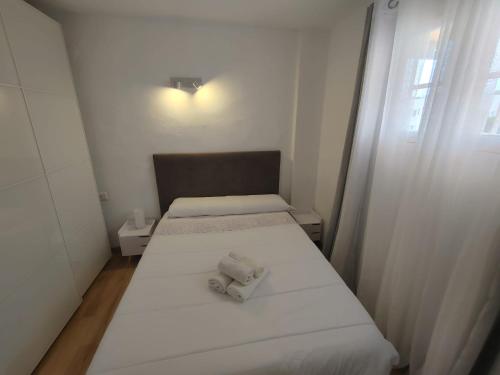 Cette petite chambre comprend deux lits et une chaise. dans l'établissement Formentera suite 13, à Es Pujols