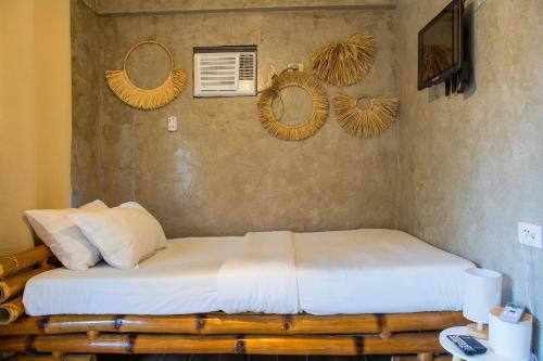 a bedroom with two beds and a wall with mirrors at Your Brothers House Tribal Village in Legazpi