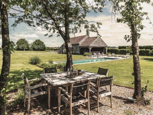 uma mesa e cadeiras num quintal com piscina em Beautiful Cottage with Pool em Ohey