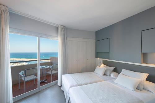 a hotel room with two beds and a view of the ocean at Hotel El Puerto by Pierre Vacances in Fuengirola