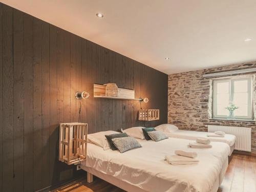 a bedroom with two beds and a brick wall at Beautiful Cottage with Pool in Ohey