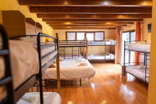a room with several bunk beds in a building at Hotel Golf Natura in La Coma i la Pedra