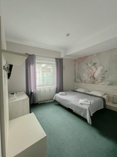 a bedroom with two beds and a painting on the wall at Hotel Poleski in Krakow