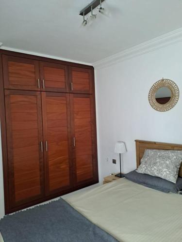 a bedroom with a bed and a large wooden closet at Dunas de Famara in Famara