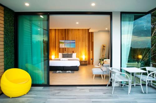 a hotel room with a bed and a table and chairs at Ao Luek Panoramic Pool-SHA Plus in Ao Luk