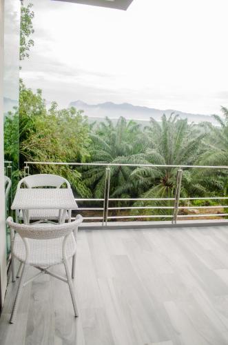 a balcony with a table and a view of palm trees at Ao Luek Panoramic Pool-SHA Plus in Ao Luk