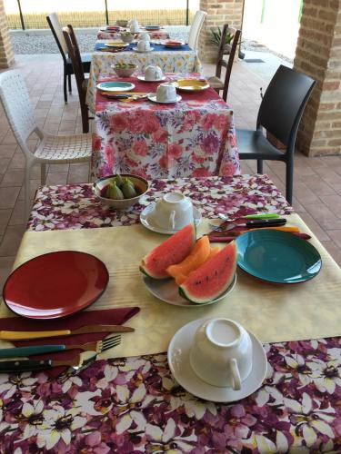 een tafel met borden eten en fruit erop bij B&B Casa Egle in Corbola