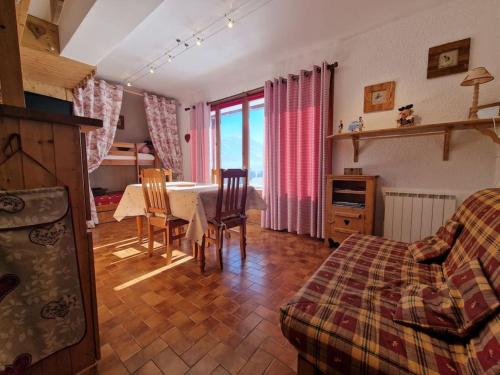 a living room with a bed and a table and chairs at Appartement - Vue Mont-Blanc in Cordon