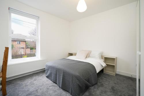 a white bedroom with a bed and a window at Charlotte House, entire private house, close to city centre, WiFi in Sheffield
