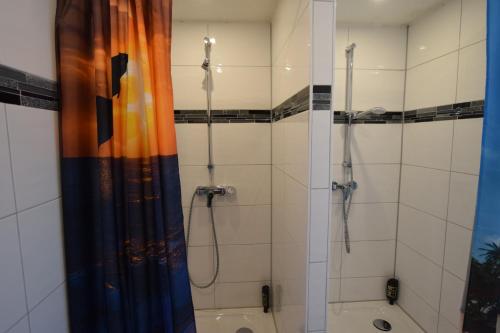 La salle de bains est pourvue d'une douche et d'un rideau de douche. dans l'établissement Apartment Maichingen, à Sindelfingen