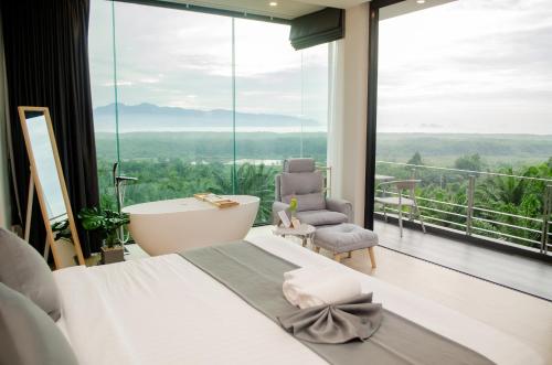 a bedroom with a bath tub and a large window at Ao Luek Panoramic Pool-SHA Plus in Ao Luk