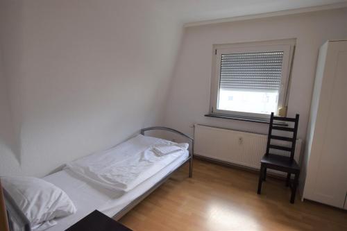 - une chambre avec un lit, une chaise et une fenêtre dans l'établissement Apartment Maichingen, à Sindelfingen