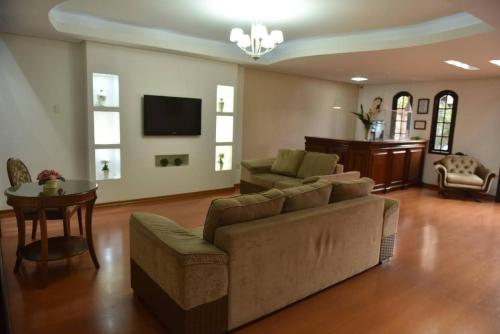 a living room with a couch and a table at Pousada Normandy in São Lourenço