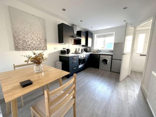 a kitchen with a wooden table and a dining room at Thorpe House - Home Crowd Luxury Apartments in Doncaster