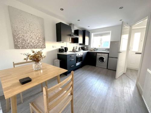 una cucina con tavolo in legno e una sala da pranzo di Thorpe House - Home Crowd Luxury Apartments a Doncaster