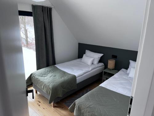sypialnia z 2 łóżkami i oknem w obiekcie Chatki Między Górami w mieście Sosnówka
