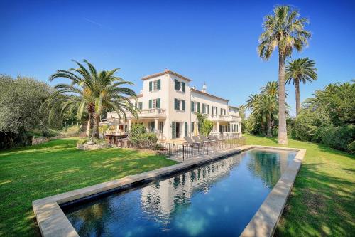 une grande maison avec une piscine dans la cour dans l'établissement LE BEAUVERT Belle Epoque luxury villa of 500 m2 with pool, à Antibes