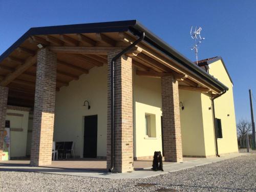 a building with a black dog sitting in front of it at B&B Casa Egle in Corbola