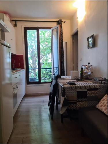 uma cozinha com uma mesa e uma grande janela em F2 au cœur de Paris em Paris