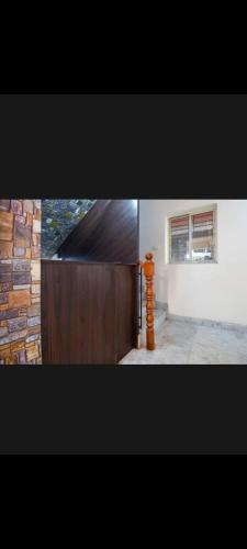 um quarto com uma cerca de madeira e um edifício em OYO Cv Guest House Near Rdb Cinemas em Calcutá