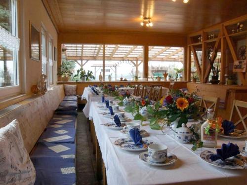 a long table with plates and cups and flowers on it at Haflinger Reiterhof Meura in Meura