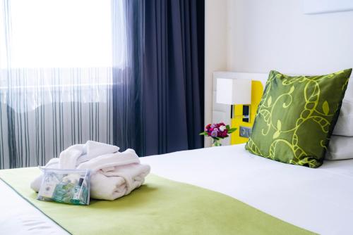 a hotel room with a bed with a pile of towels at Best Western Plus Hôtel Le Rhénan & Restaurant Chez Claude in Dorlisheim