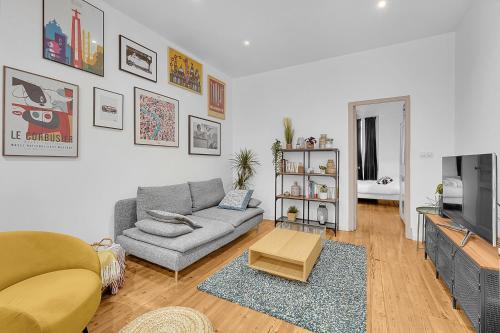 un salon avec un canapé et une télévision dans l'établissement Le Clos Dupont - Appartement avec jardin et terrasse à Toulouse, à Toulouse