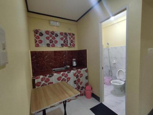 a small bathroom with a toilet and a table at 8-pax Jumongs Transient in Bantay