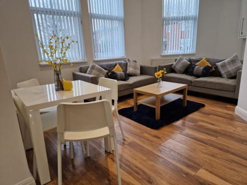 a living room with a table and a couch at Newly Furnished Close to City Centre in Hunslet