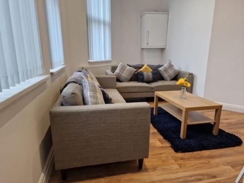 a living room with a couch and a table at Newly Furnished Close to City Centre in Hunslet