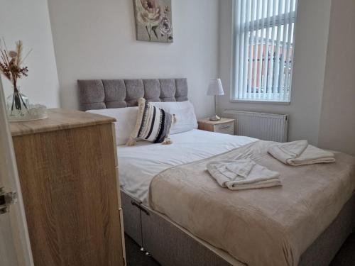 a bedroom with a bed with two towels on it at Newly Furnished Close to City Centre in Hunslet