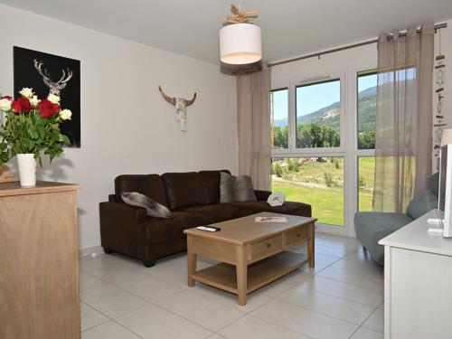 un salon avec un canapé et une table dans l'établissement Bel appartement moderne au Golf avec terrasse et parking - FR-1-165A-102, à Barcelonnette