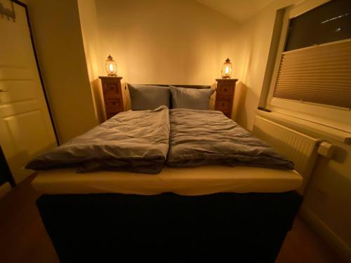 een bed in een kamer met een raam en 2 verlichting bij Hochheide Lodge in Winterberg